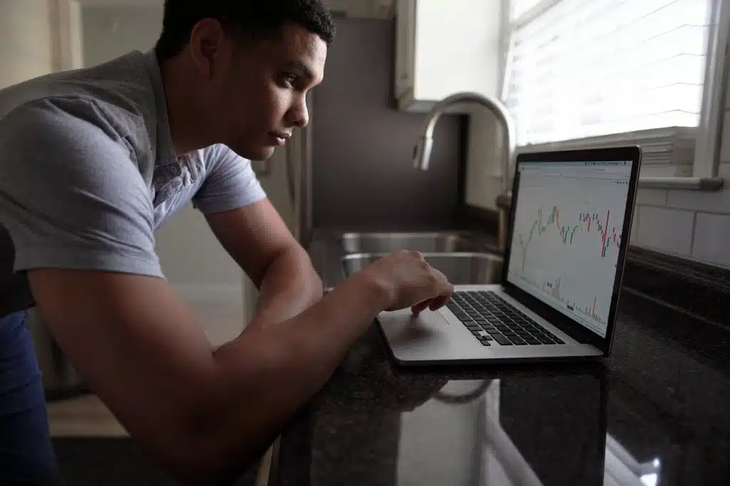 אדם לומד גרף שוק ההון על גבי המחשב תוך כדי שמשתמש באנגלית העסקית שלו להבין את התחזיות
